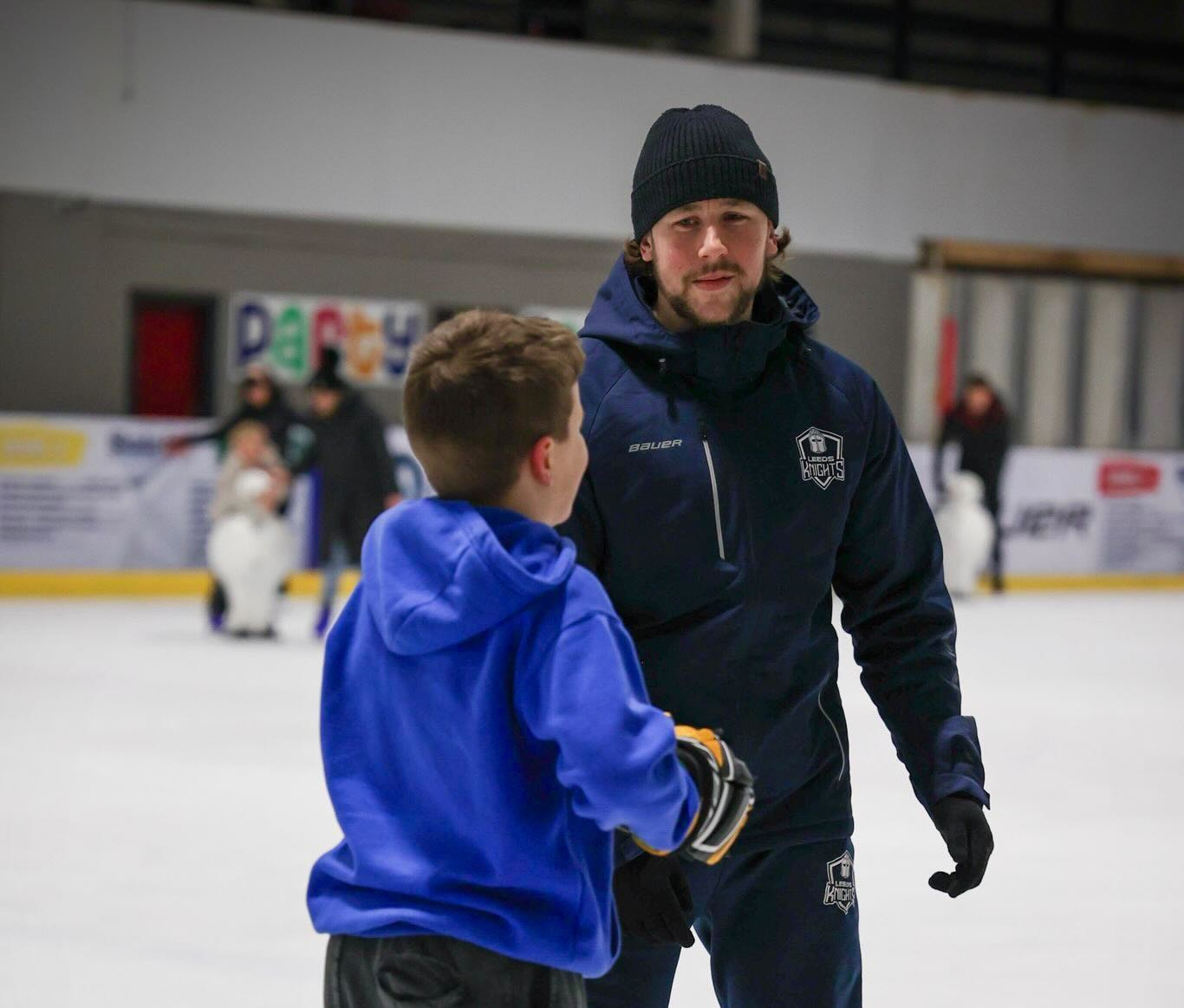 Kieran Brown coaching a young player on the ice