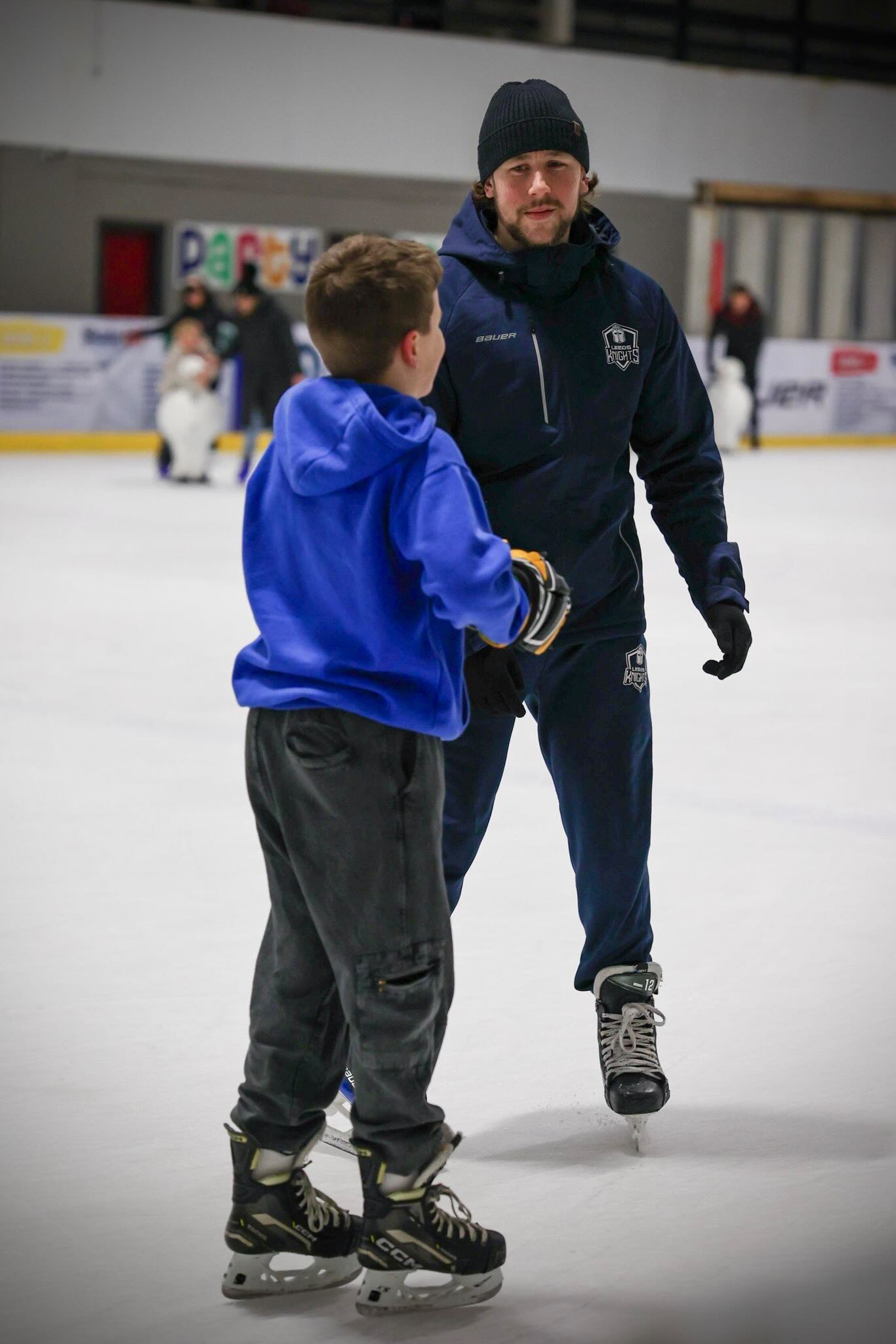 Kieran Brown coaching a young player on the ice